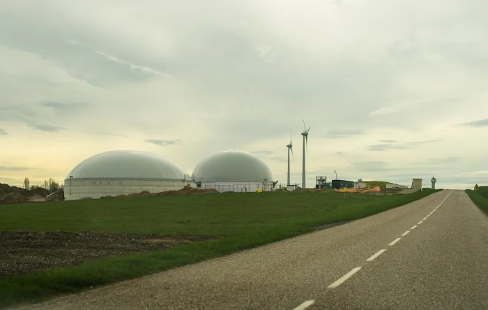 Biogasanlage mit Windräden im Hintergrund