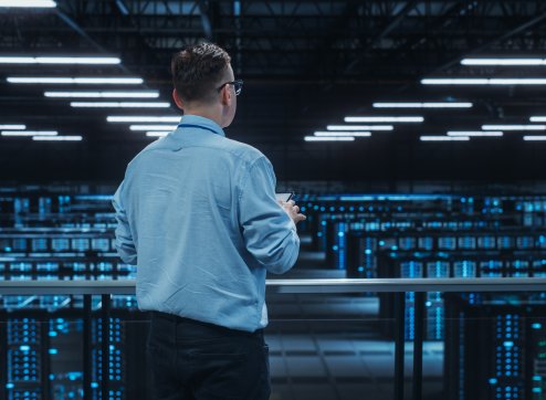 Hochtechnologisches Datacenter mit beleuchteten Serverschränken zur Gewährleistung der Ausfallsicherheit bei PowerUP.