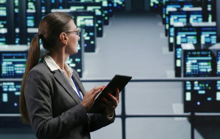 Bild eines Technikers, der eine Serverfarm in einem beleuchteten Rechenzentrum prüft